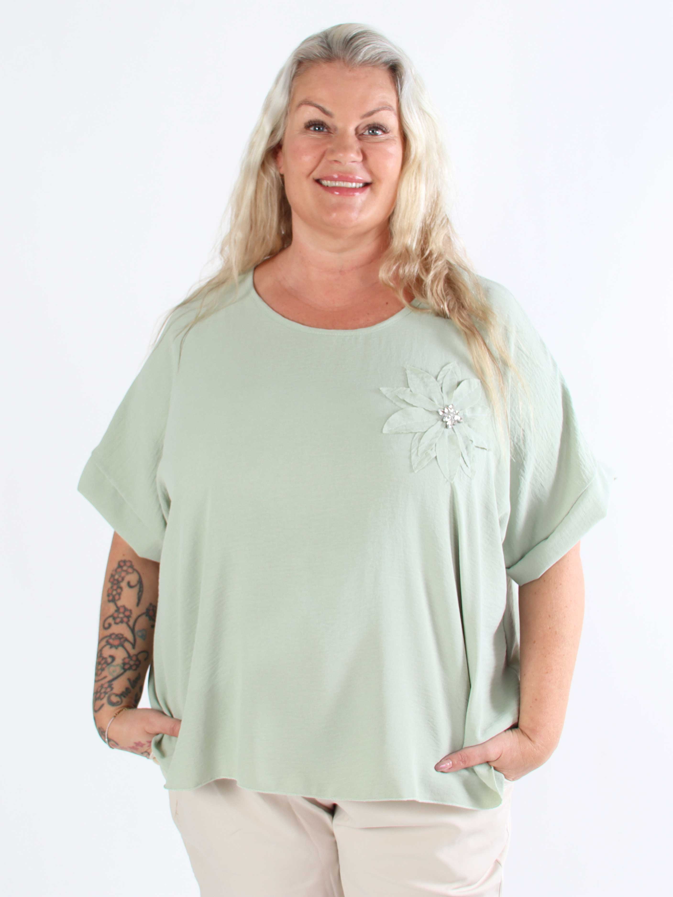 Tabisha - Plus size tunika med blomst og similisten på brystet