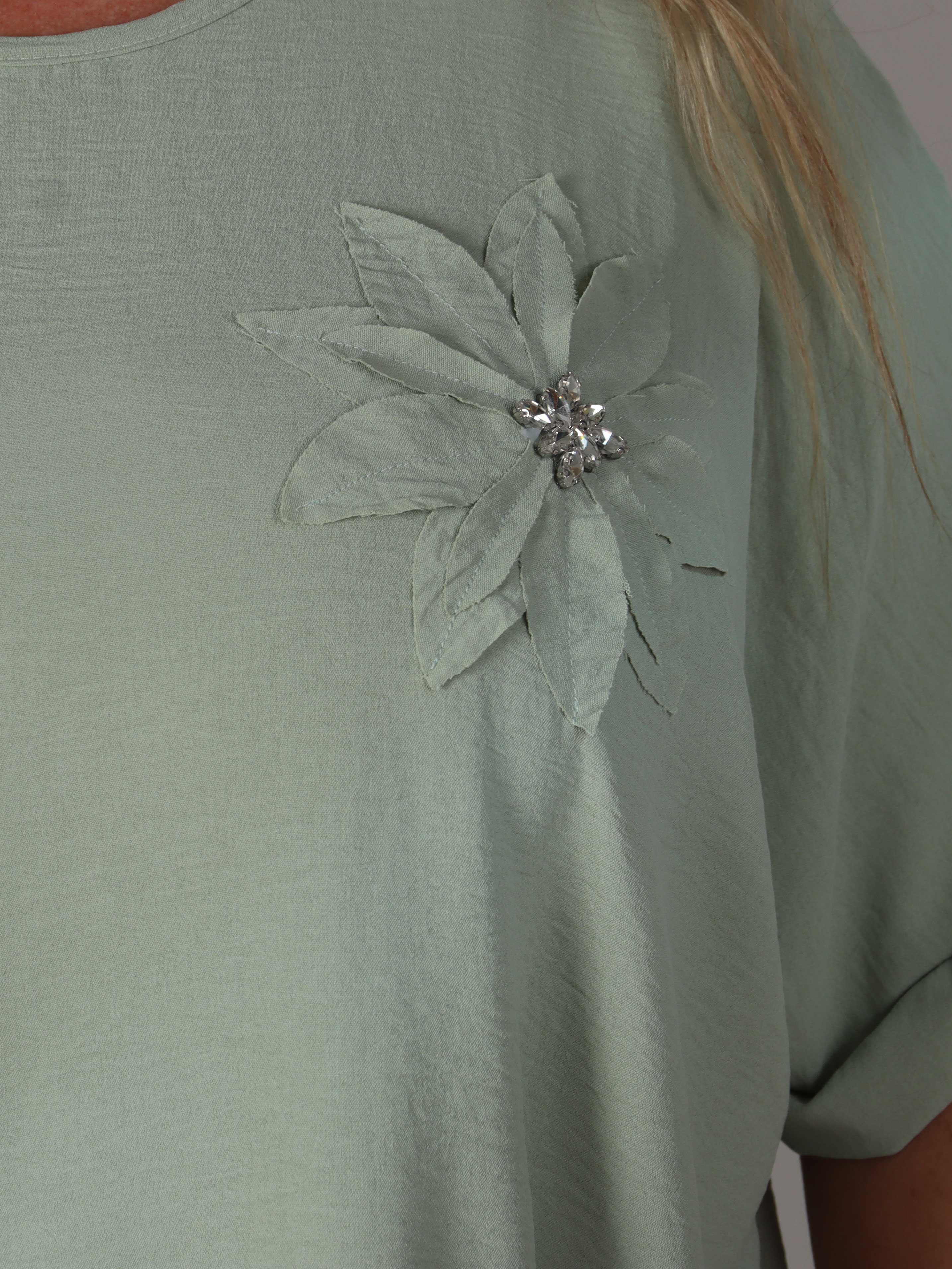 Tabisha - Plus size tunika med blomst og similisten på brystet