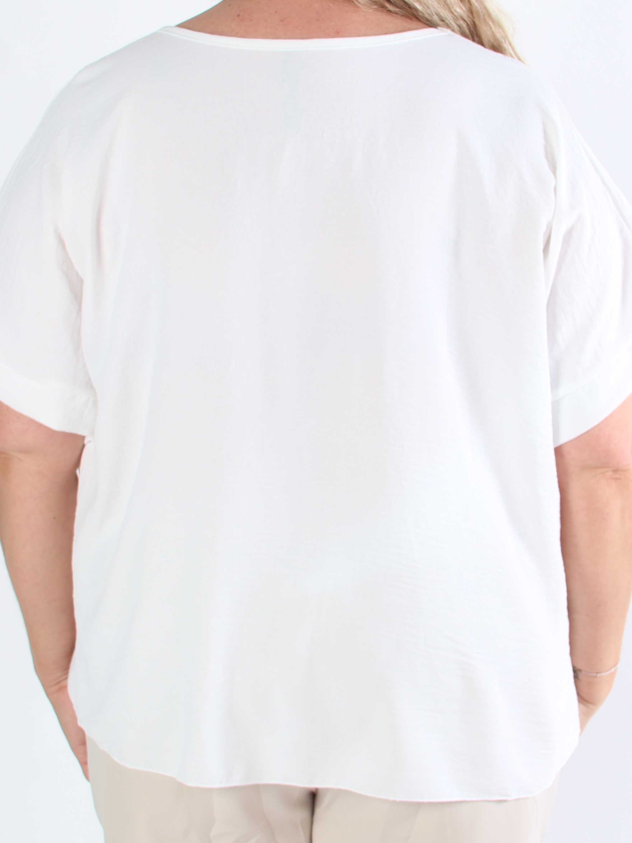 Tabisha - Plus size tunika med blomst og similisten på brystet