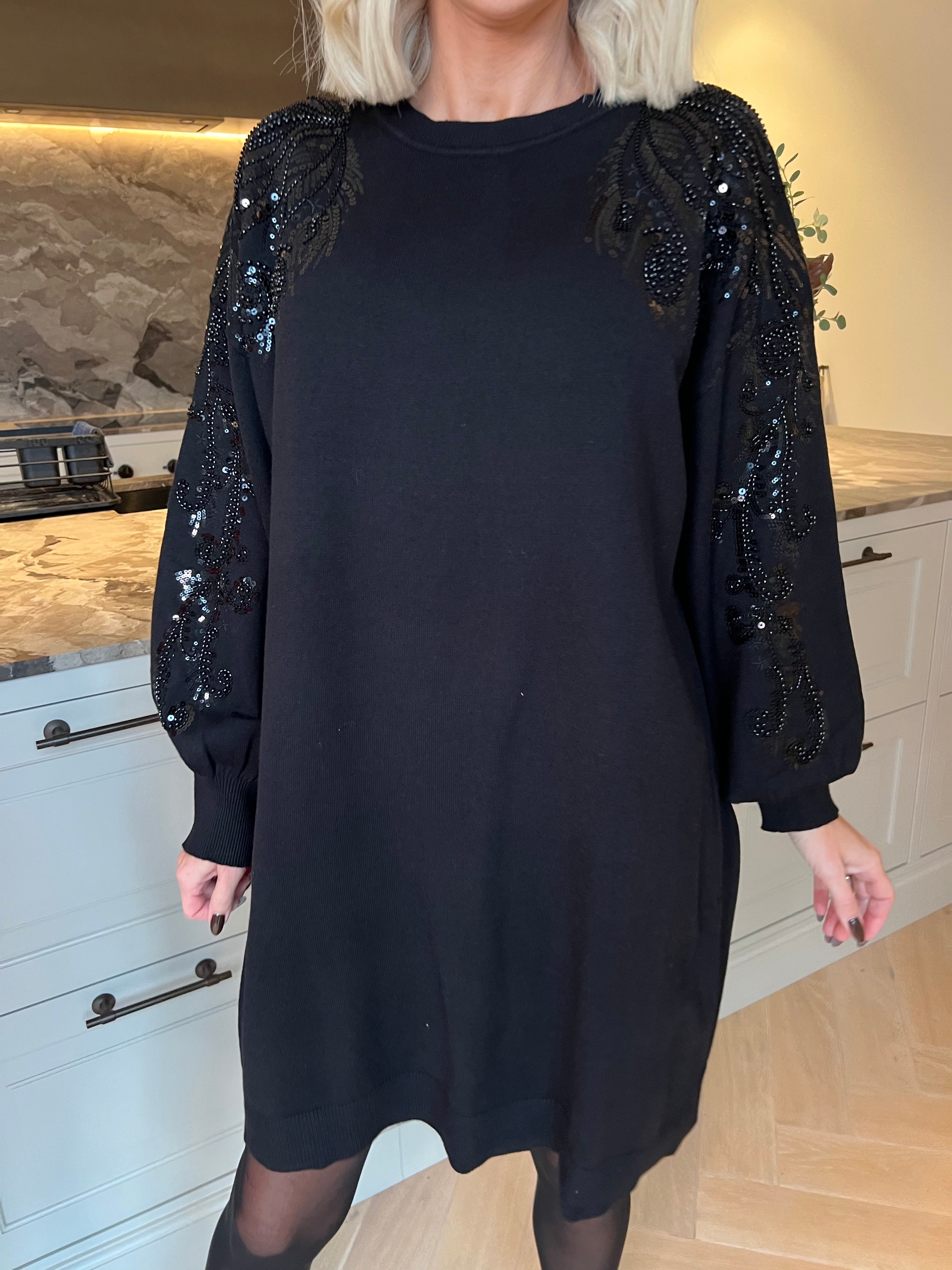 Juliana - Blød og stretchy strikkjole med et smukt mønster af glitrende pailletter og perler på ærmet