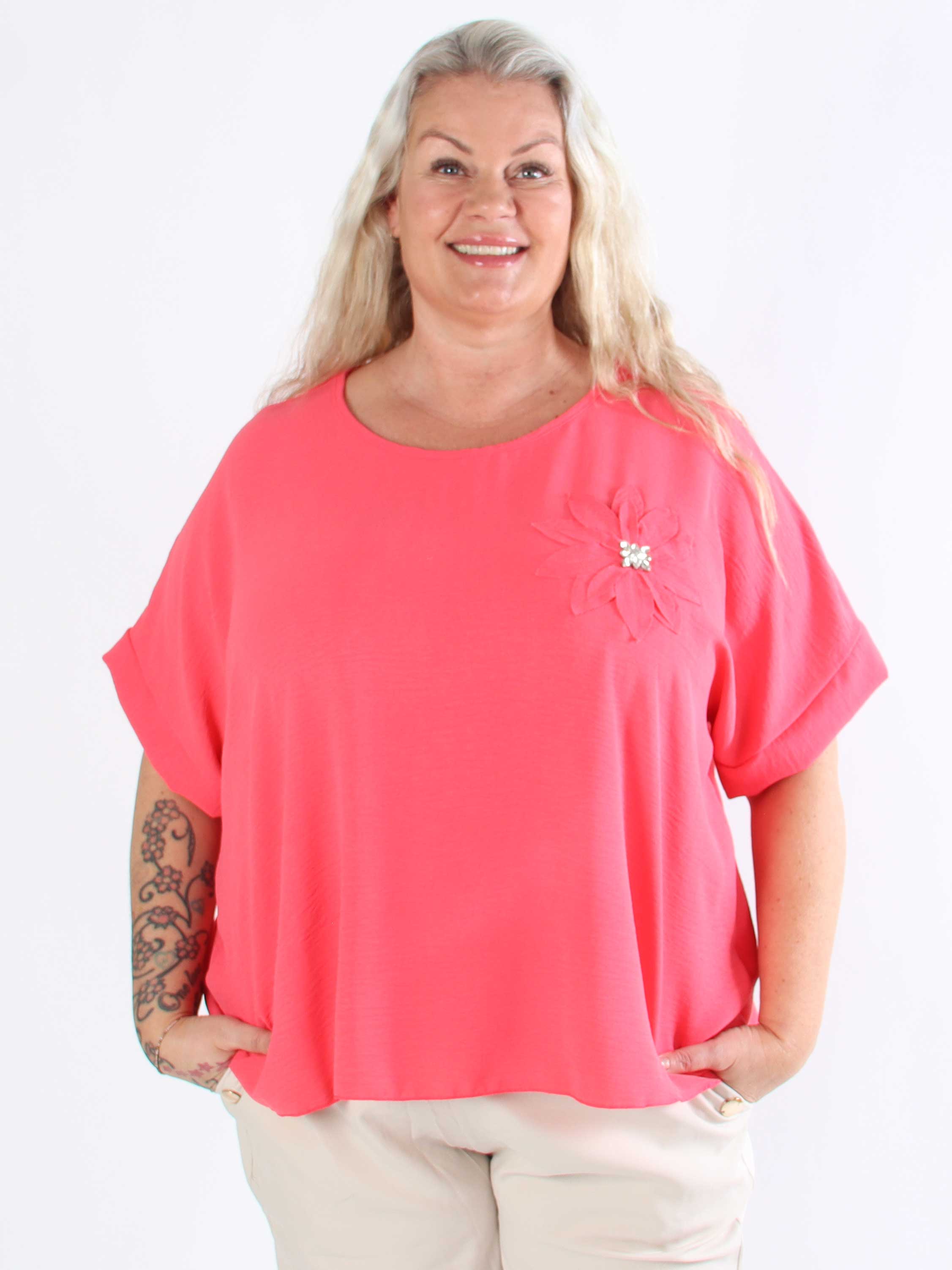 Tabisha - Plus size tunika med blomst og similisten på brystet